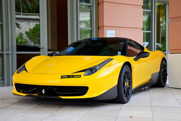 Ferrari jaune sur fond de façade de bâtiment
