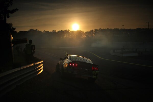 Ford Mustang drifting in the rays of the setting sun