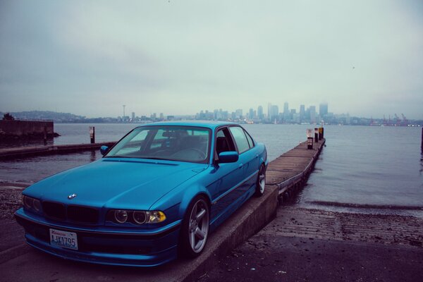 Desktop-Hintergrund BMW e38 auf dem Hintergrund des Meeres und der Stadt