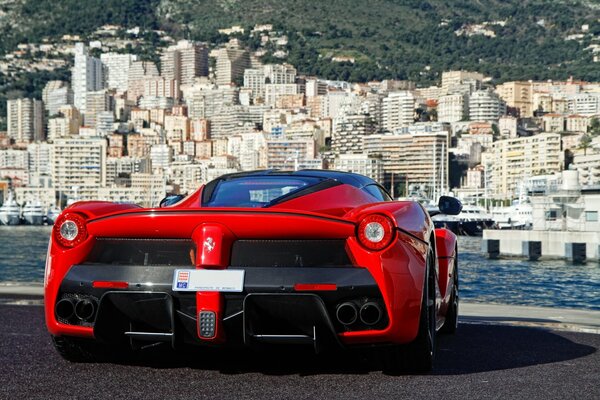 Czerwone Ferrari na tle dużego miasta