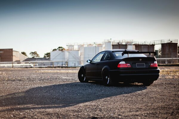 Mattschwarzer BMW mit Spoiler auf Tankhintergrund