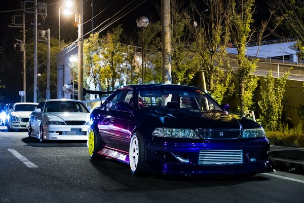 Cars are parked on the street at night