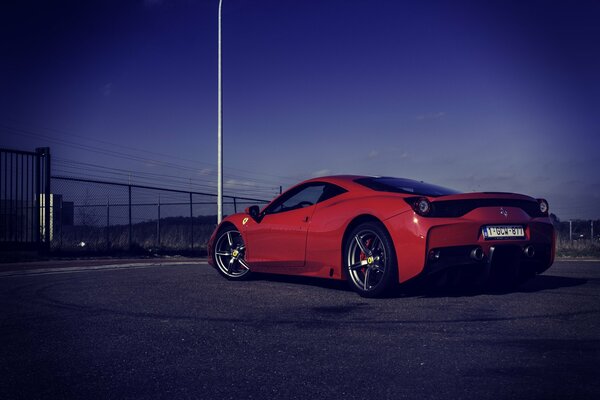 Czerwone włoskie Ferrari na drodze wieczorem