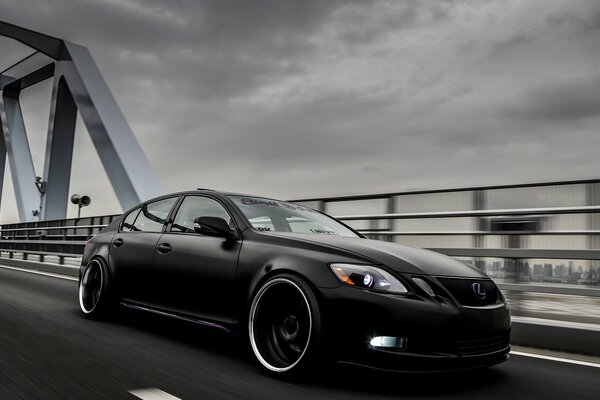 Lexus black car rushes over the bridge