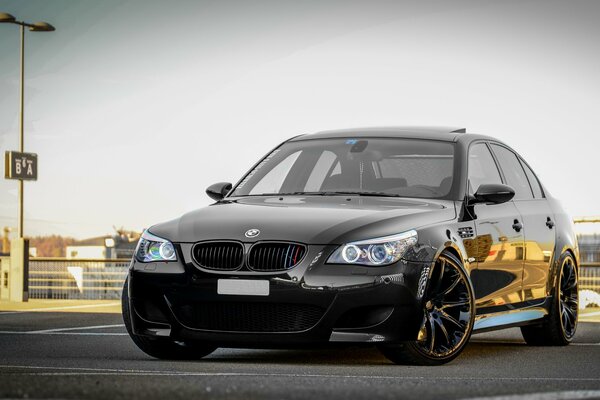 Black BMW in an open-air parking lot