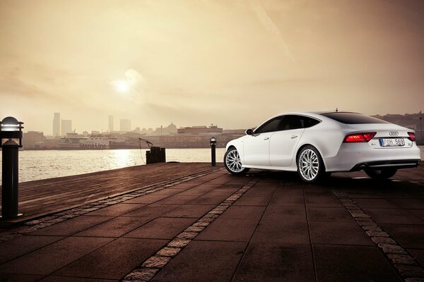 Voiture argentée Audi A7 sur le quai de la rivière