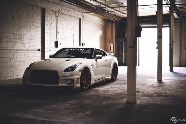 The Nissan gtr car is in the garage during daylight hours