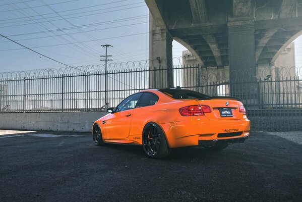 Orange BMW derrière la clôture en fil de fer barbelé
