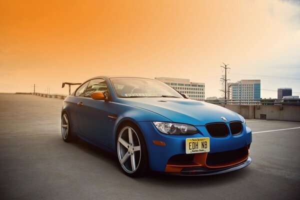 An understated bmw in blue is driving at sunset