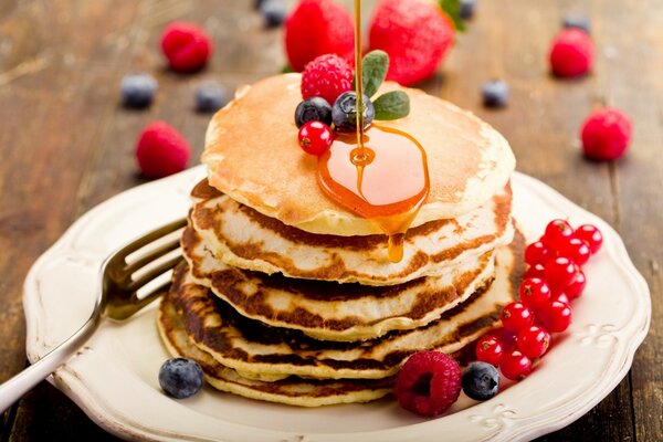 Delicious, sweet pancakes with honey and berries