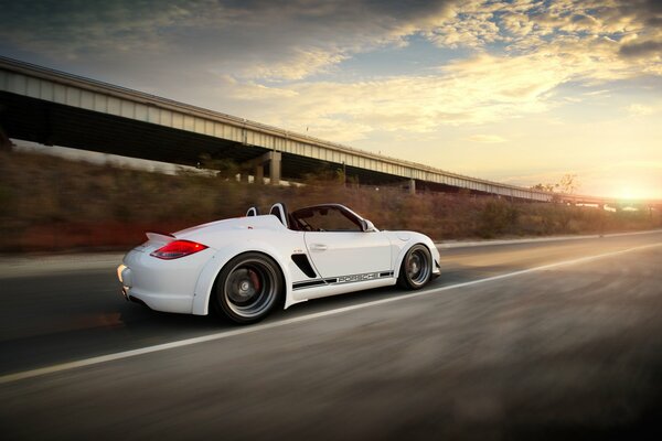 Hermoso coche blanco conduce rápido en la carretera