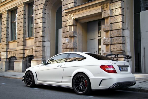 Weißer Mercedes Benz fährt durch die Stadt