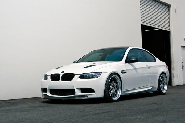 Beautiful white BMW on the background of a white building
