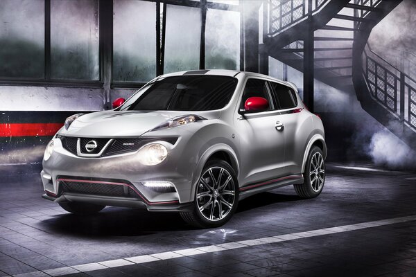 Nissan Juke NISMO blanco contra escaleras y humo