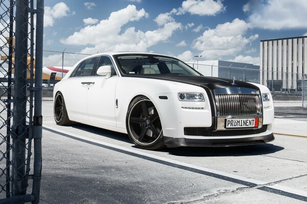 White ghost rolls royce on the background of clouds