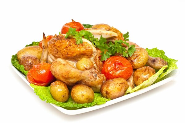 Картофель, курица и помидоры на блюде