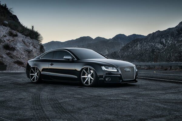 Black audi among the hills on the road