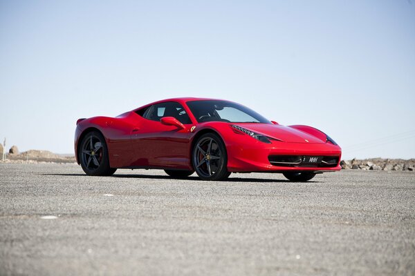 Foto de un coche rojo contra un fondo de asfalto gris