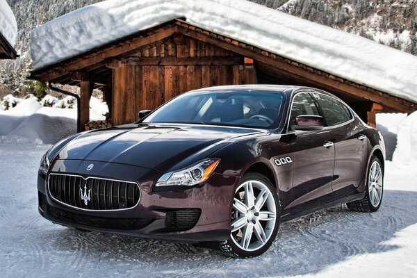 Italienisches Maserati-Auto im Hintergrund einer Scheune im Winter