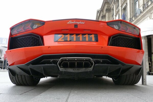 Vista trasera de un Lamborghini naranja con un potente tubo de escape