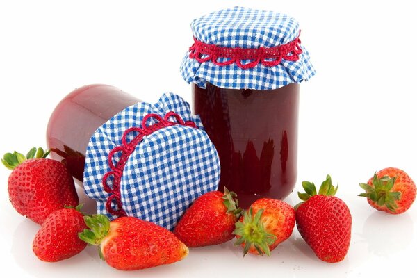 Lovely jars of jam next to fresh strawberries