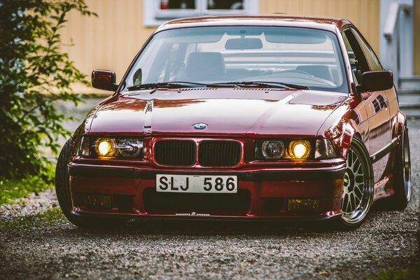 Red tuned BMW in the shade with numbers