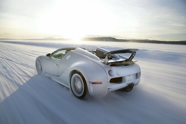 White bugatti veyron rushes on a snowy highway