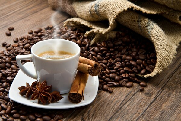 Café aromático con canela sobre un fondo de granos