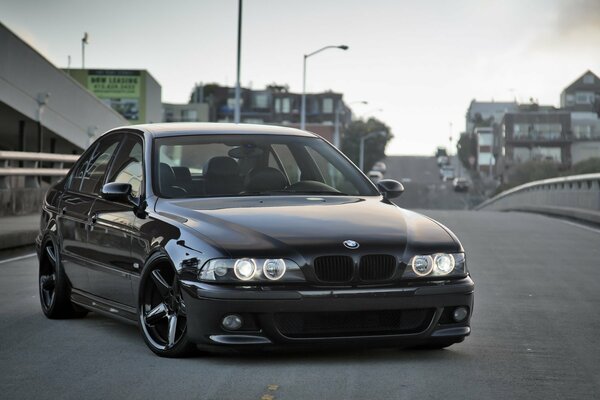 Black BMW on the background of houses