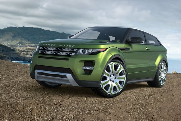 Vehículo verde Land Rover contra el cielo y la montaña