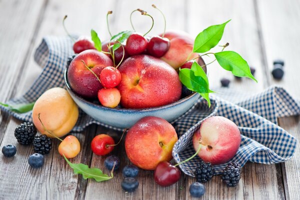 Baies et fruits dans un bol sur une table en bois