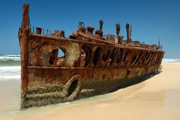 Viejo barco oxidado en la playa