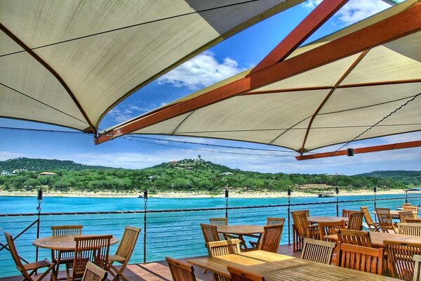 Markisen über der Veranda auf einem Hintergrund mit blauem Meer und Insel