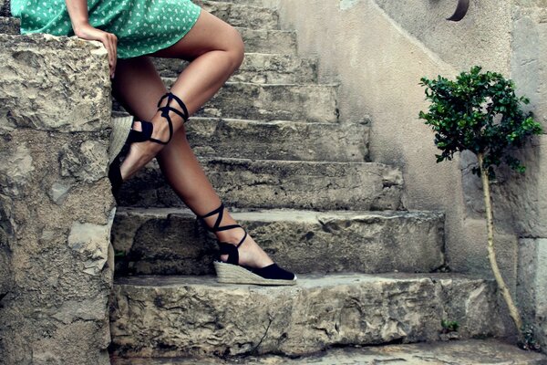 Legs of a girl np on the background of a stone staircase