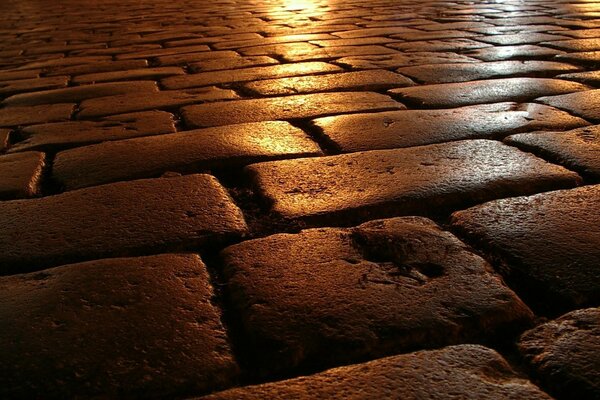 Paving stones on asphalt, reflection of color on paving stones