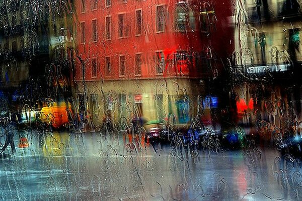 Verre dans les gouttes de pluie sur le fond de la rue de la ville