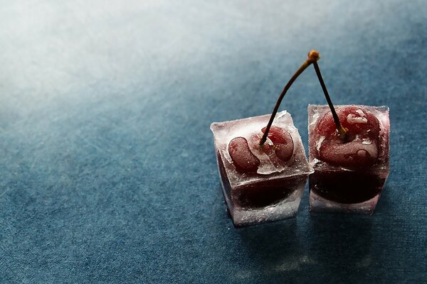 Dos cerezas congeladas en la mesa