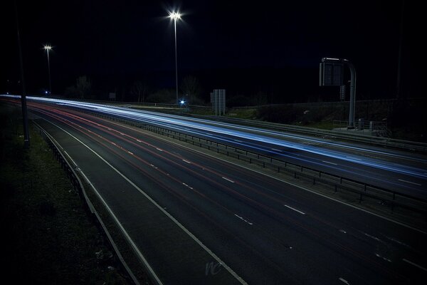 Un camino nocturno y vacío brilla con luces