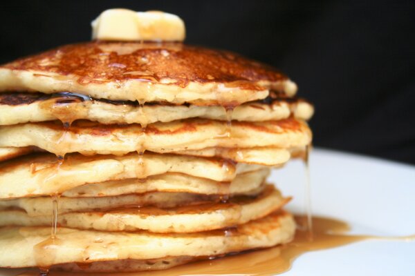 Stopa Pancake ów podlewanych miodem na białym talerzu