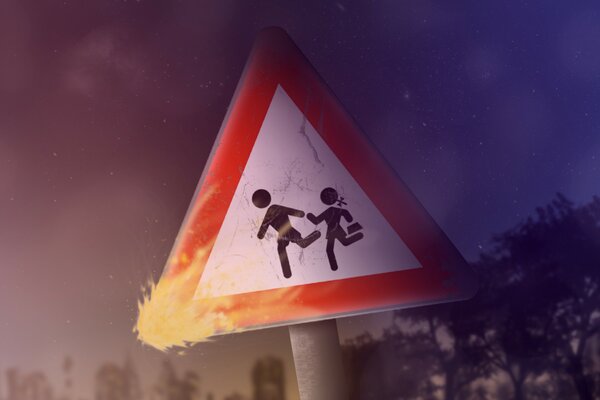 A road sign with the image of raging people. The corner of the sign is lit