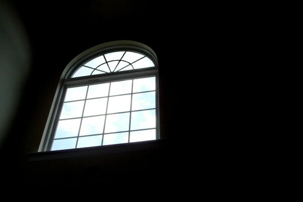 Высокое полукруглое окно, разрезающее тьму