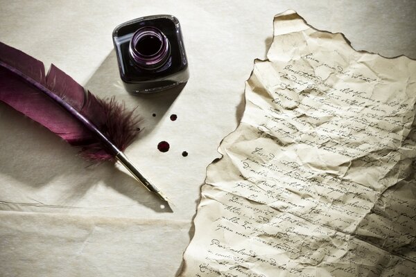 A burnt letter next to a pen and inkwell