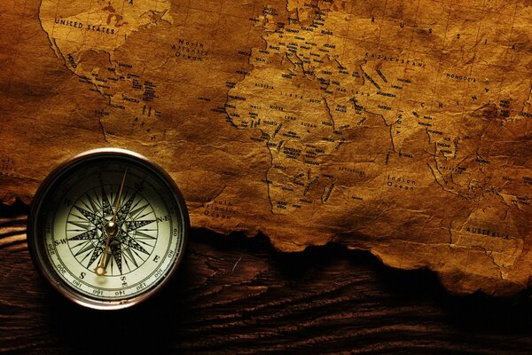 A map on a wooden table and a compass