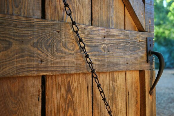 Porta in legno con maniglia e catena forgiate