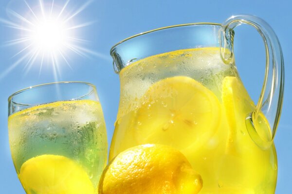 Limonada con limón en una jarra contra el sol