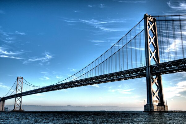 A large bridge across the water on a blue sky background