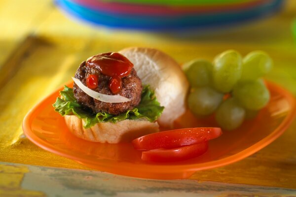 Sándwich de Muffin, tomate y ketchup, junto a las uvas