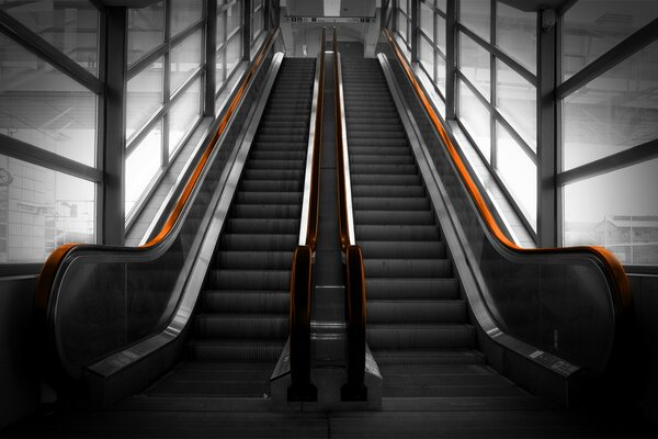 Grey escalator with orange handrails