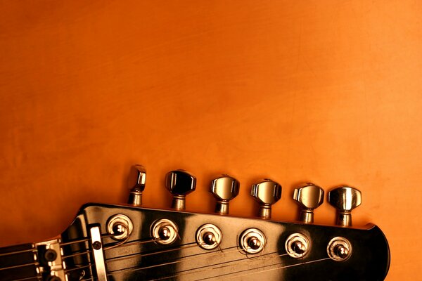 Part of the guitar on an orange background