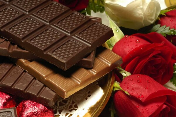 Chocolate bars on a background of red and white roses